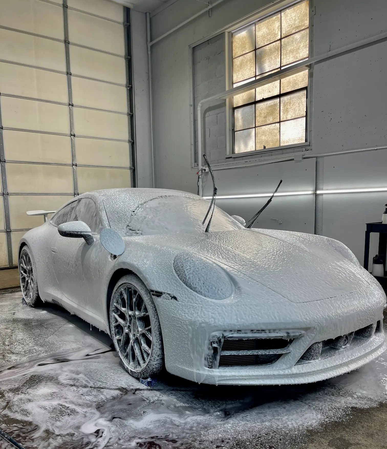 Porsche 911 coverd in foam before detailing, paint correction, and ceramic coating in kansas city