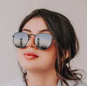 Sunglasses reflecting a clock tower.