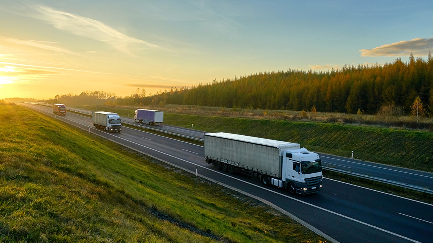 Haulage truck driving on a road in autumn, symbolizing seasonal shifts in transport demand.