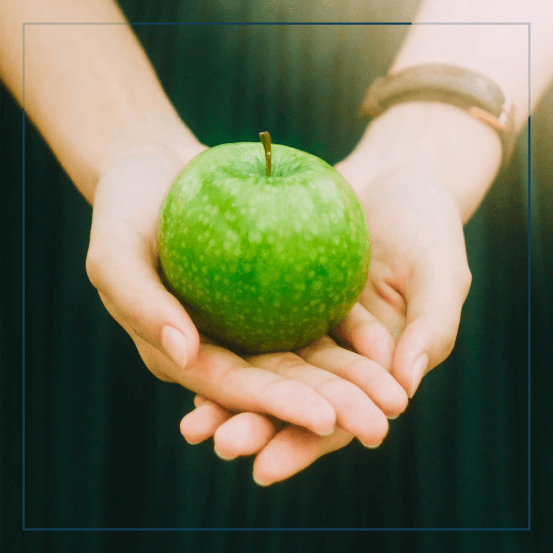 Zwei Hände auf deinen ein Apfel liegt
