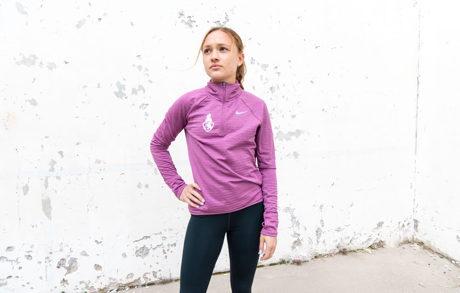 Nike shoot, a runner in a purple half-zip against the white wall