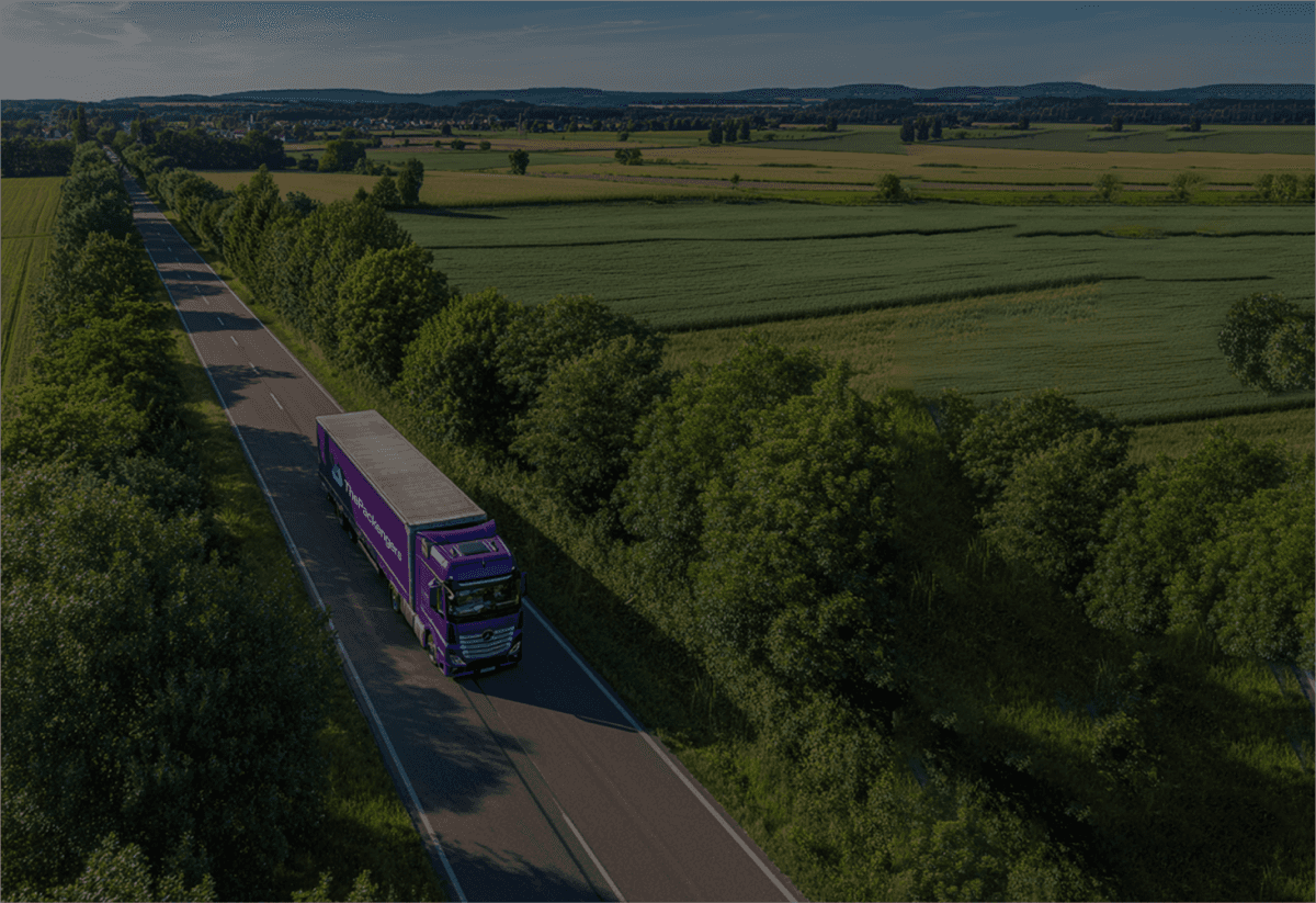 ThePackengers branded transport truck on a tree-lined road, representing eco-friendly shipping solutions, reduced carbon footprint, and recyclable packaging initiatives