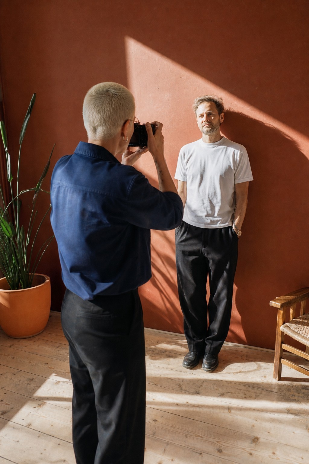 Photographer shooting a portrait against a red wall