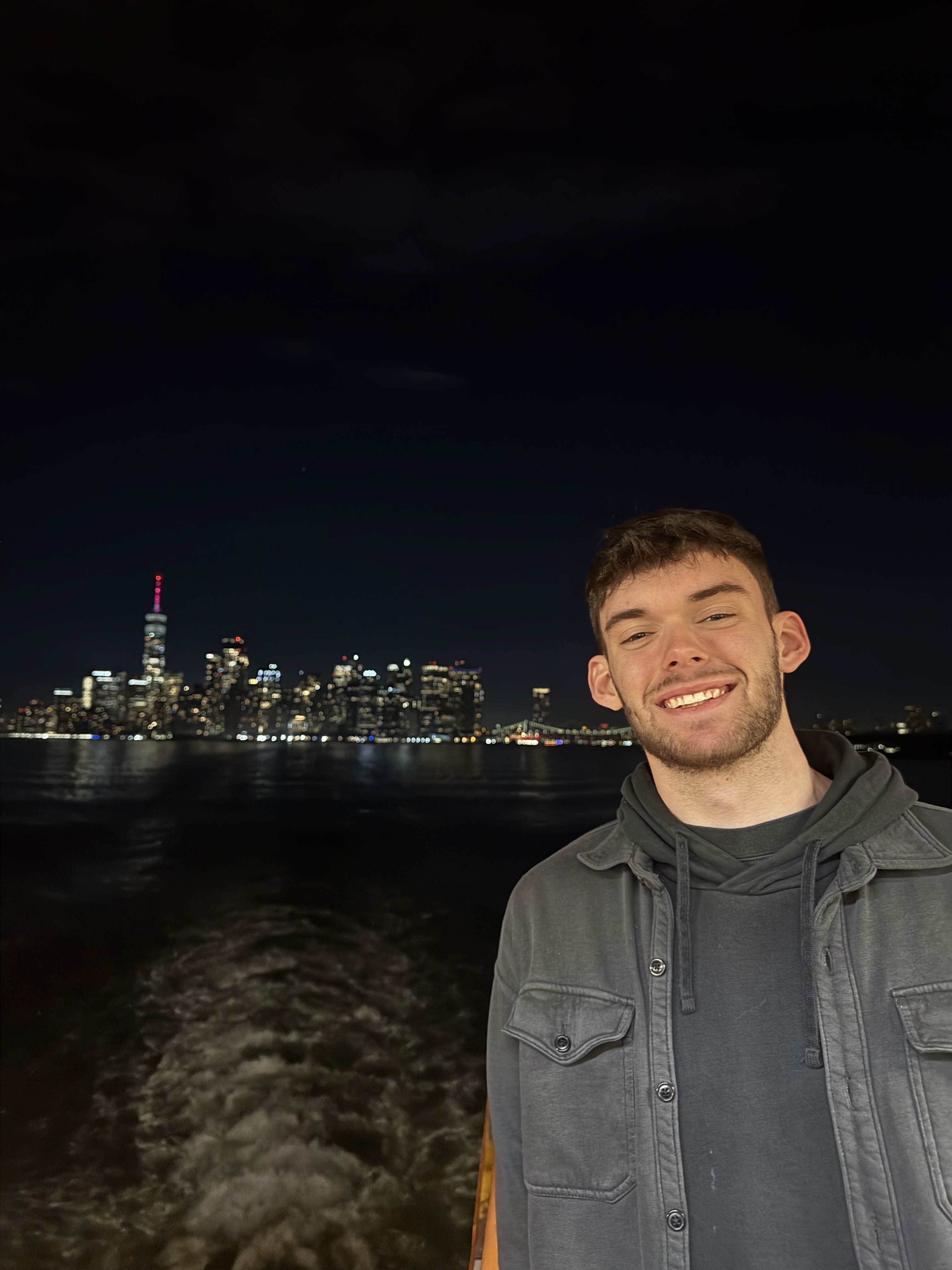A thoughtful young person with dark hair gazes to the side, captured in soft black and white lighting.