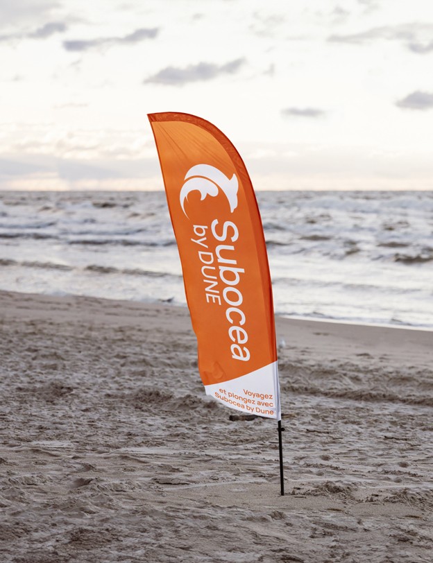 Drapeau publicitaire Subocea by Dune sur une plage.