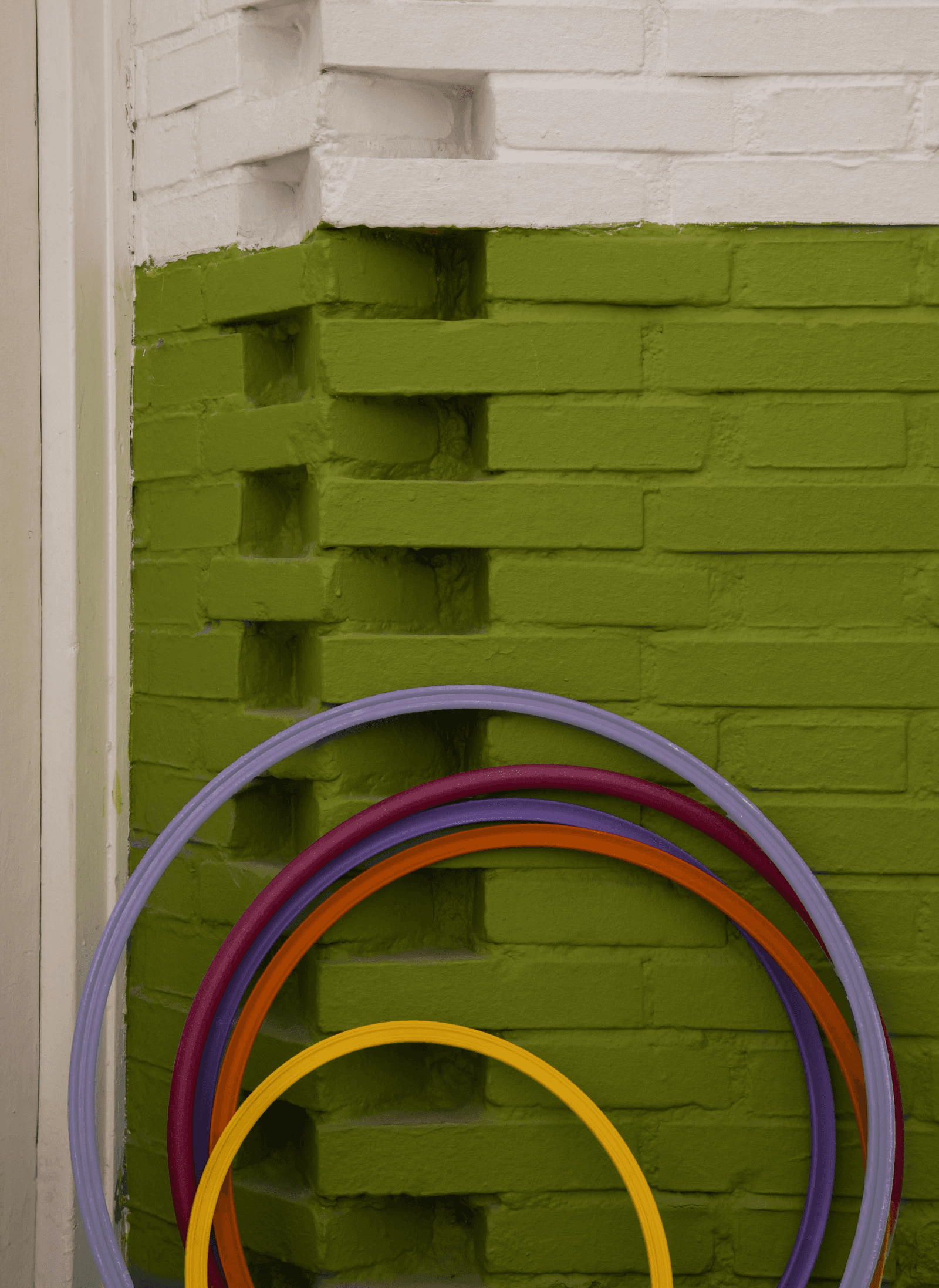 Detail of curved green brickwork and sports equipment at Los Círculos de Oíza