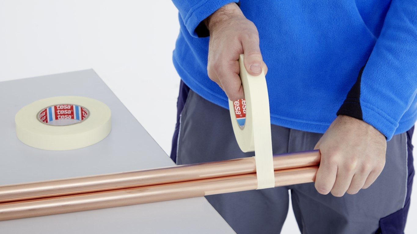 Drei Arbeiter besprechen Maschinen in einer hellen Industrieumgebung und demonstrieren dabei Teamwork und Zusammenarbeit.