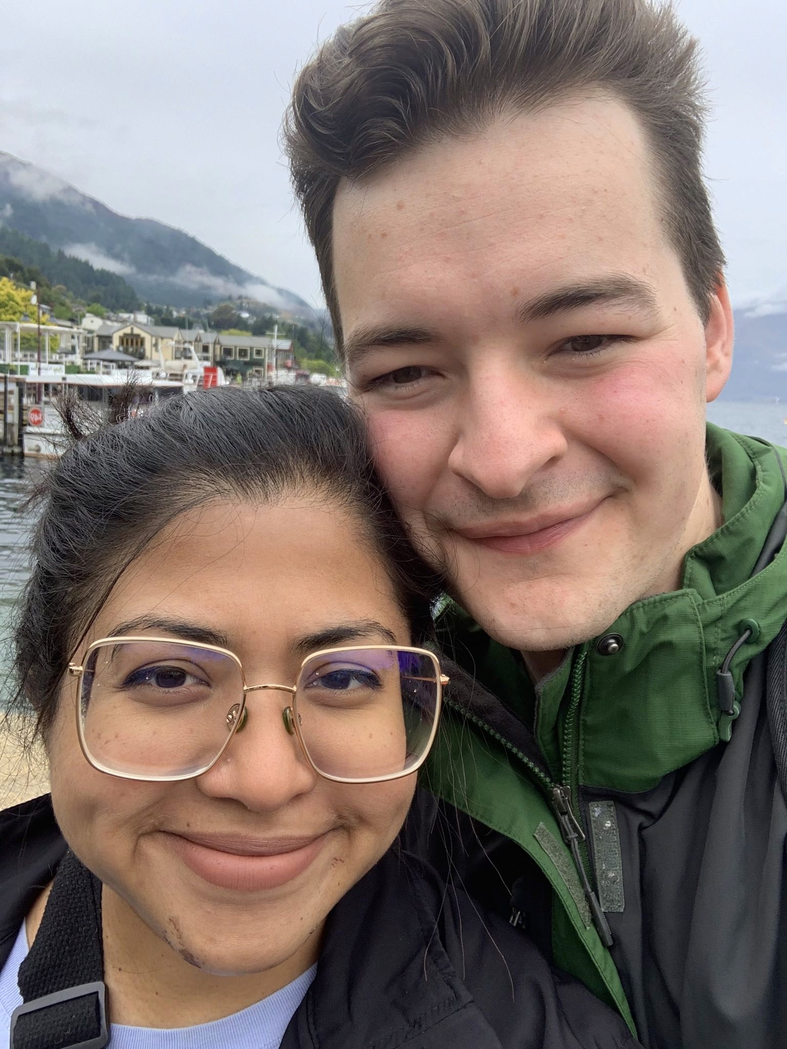 A close-up of two people holding hands, one wearing a denim jacket. The background is softly blurred, suggesting a tender, intimate moment in warm light.