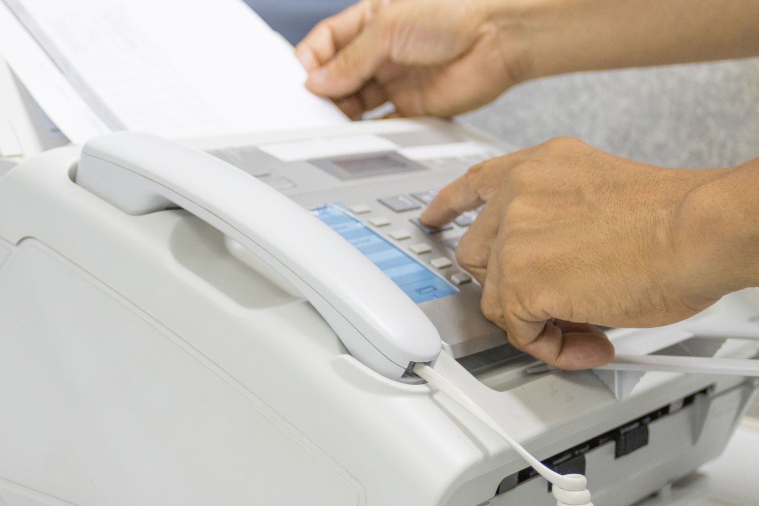 man using a fax machine