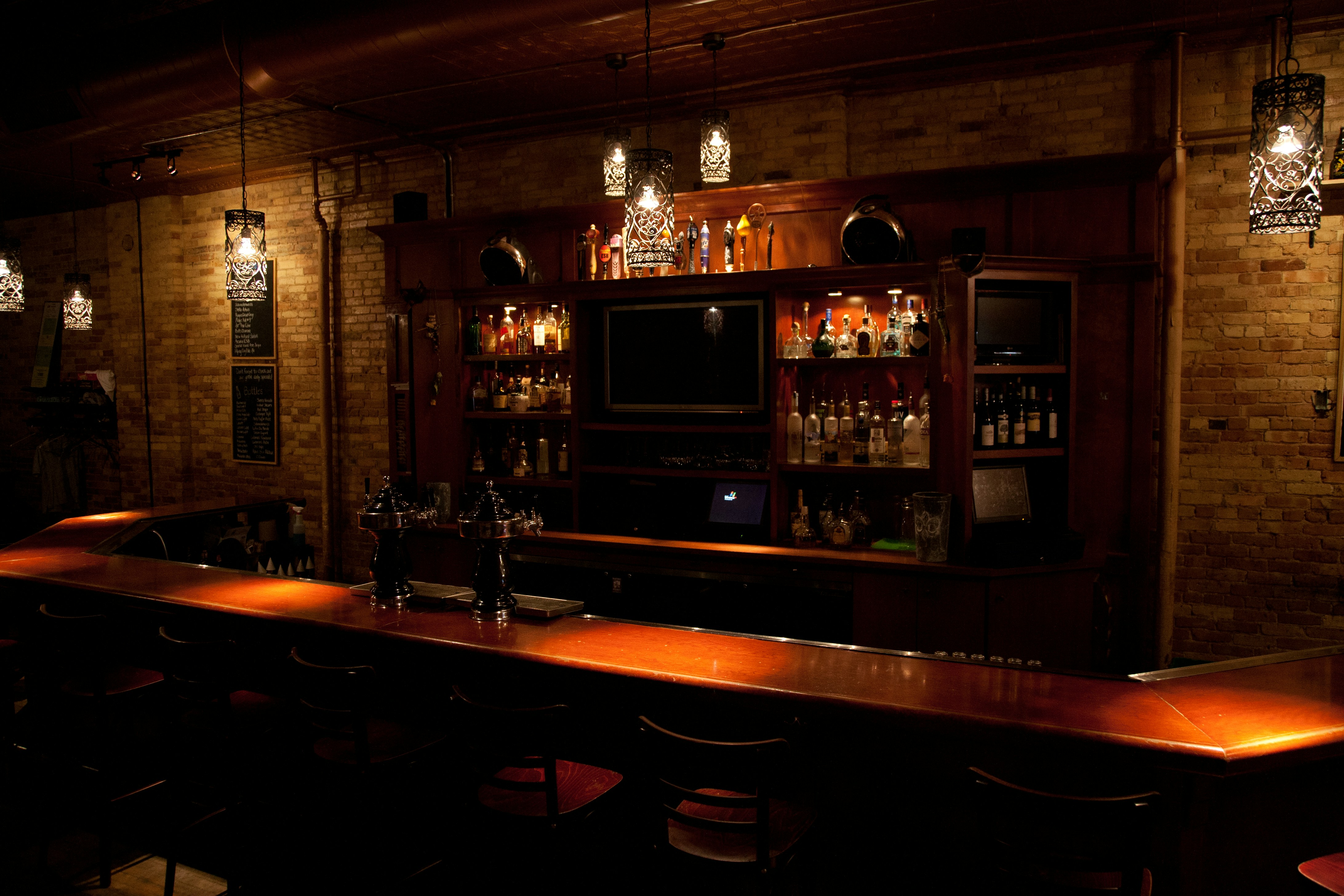 a bar with a tv and shelves of alcohol