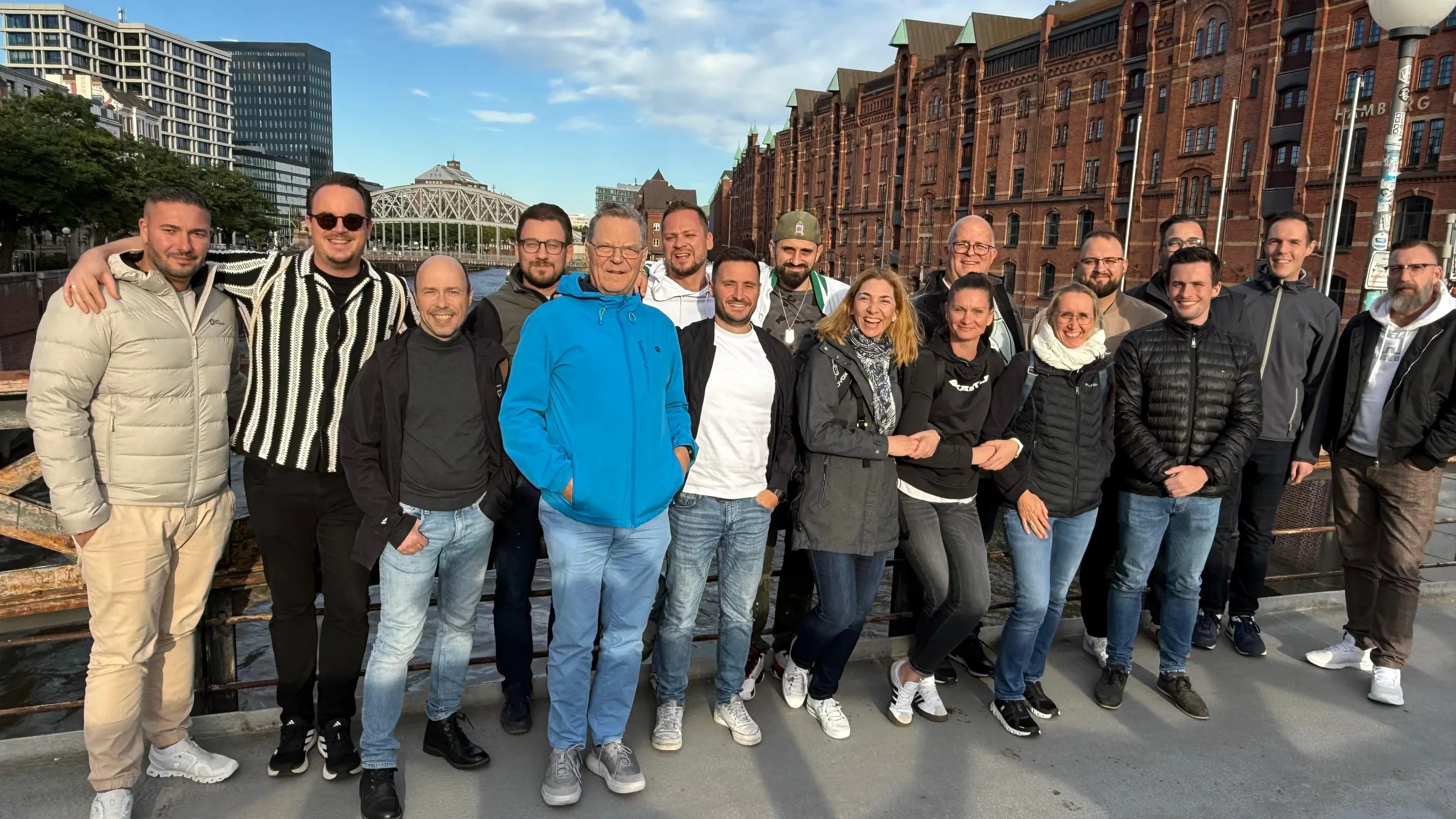 Grosses Gruppenfoto des trimaster-Teams vor den Backsteinhäusern der Hamburger Speicherstadt