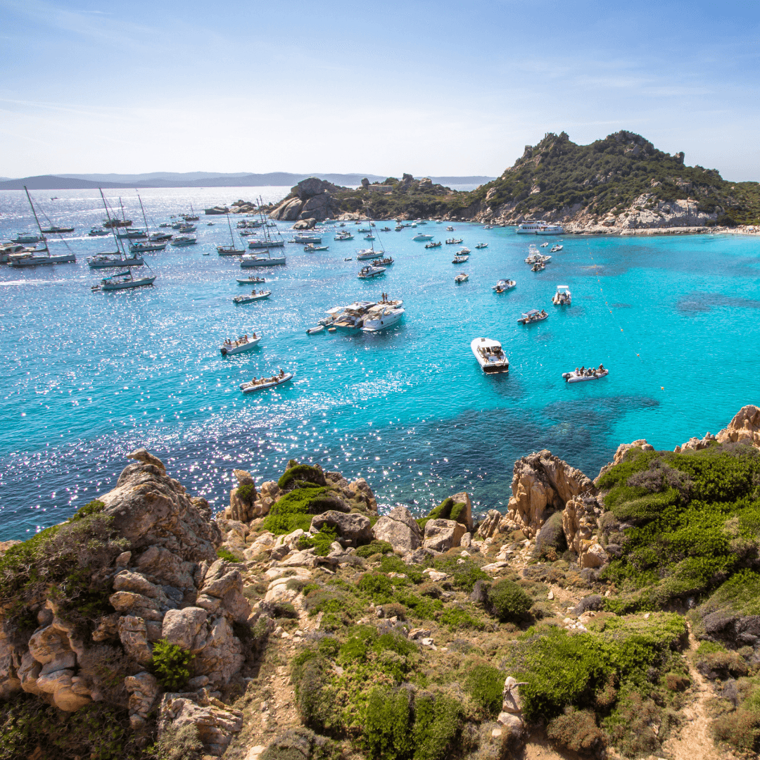 Baie turquoise en Sardaigne parsemée de bateaux, paysage minéral et marin propice au lâcher-prise et au reset mental