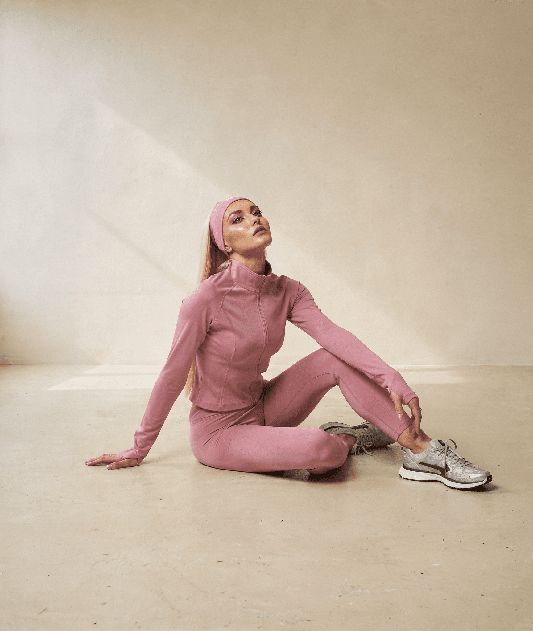 a woman sitting on a rock by the water
