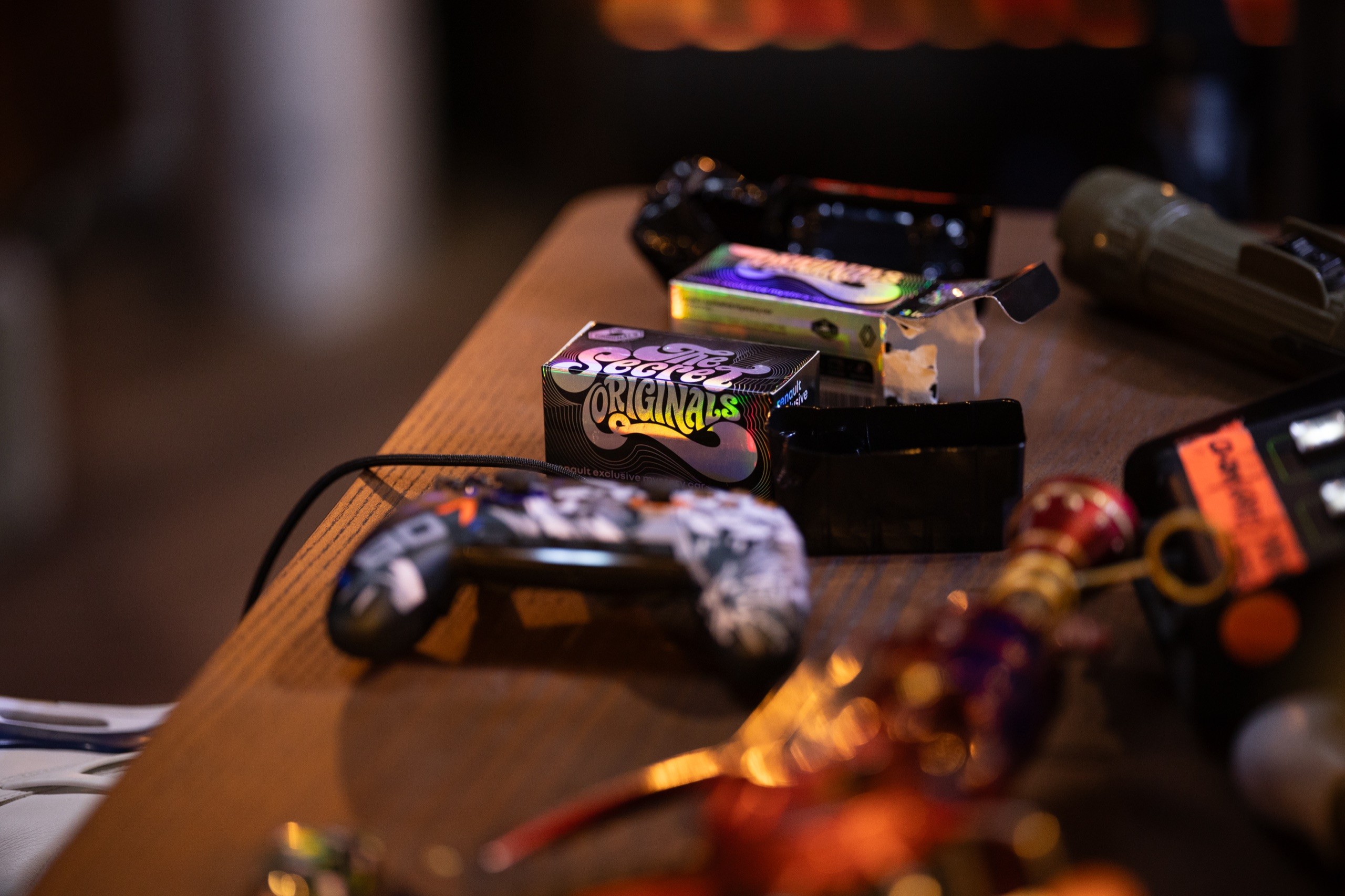 Une boîte The Secret Originals et une manette sur le bureau de jeu