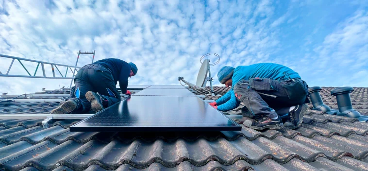 Zwei Solarteuere die eine Photovoltaik Anlage auf einem Dach installieren