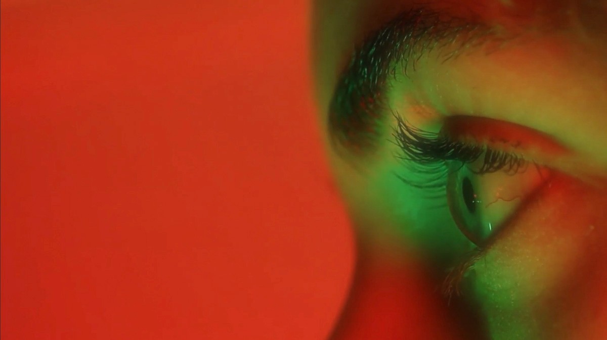 Close-up of a girls eye, dramatic green and red lighting