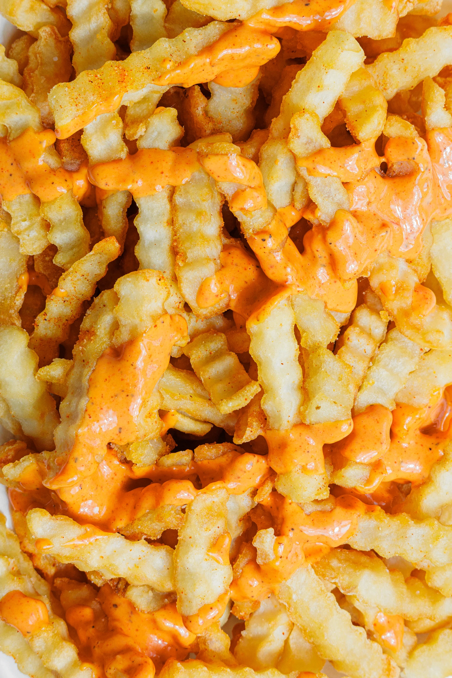 Close up view of french fries covered in sauce.