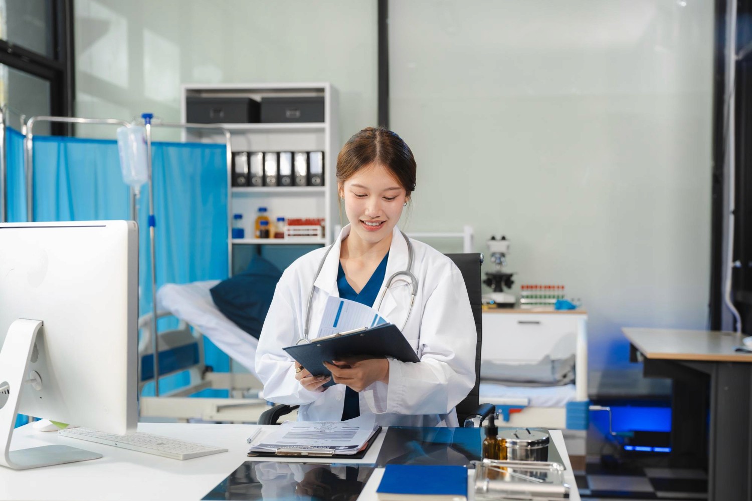 穿白袍的女醫生在香港醫務所查閱醫療報告，代表企業團體醫療保障及專業責任保險。