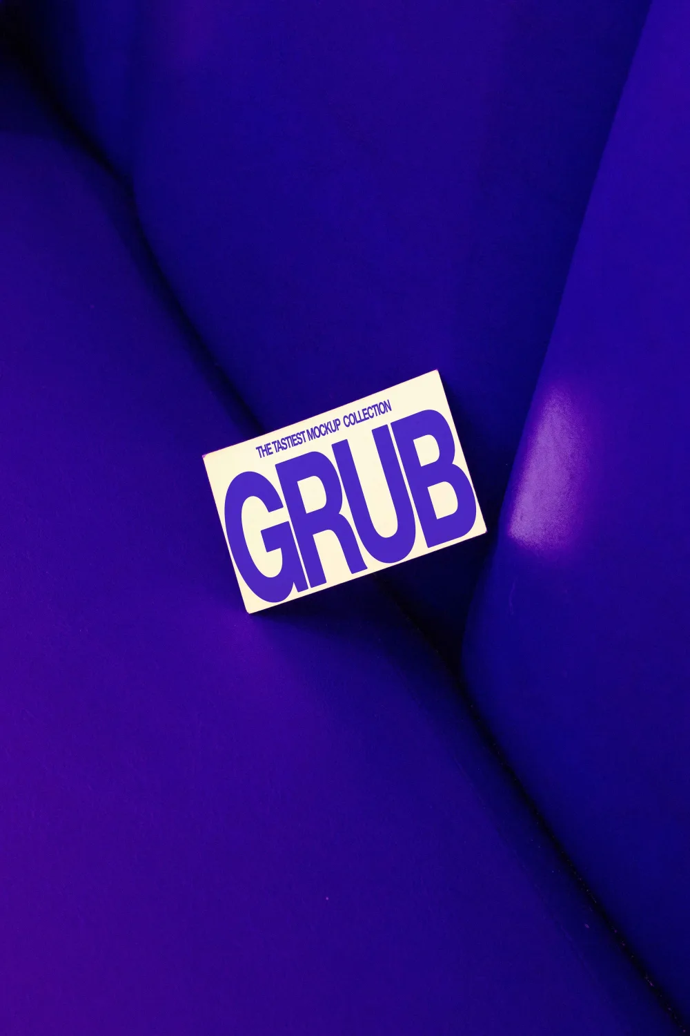 A cream-colored business card with bold purple typography placed on a deep purple leather surface. The vibrant color contrast creates a striking and modern presentation.