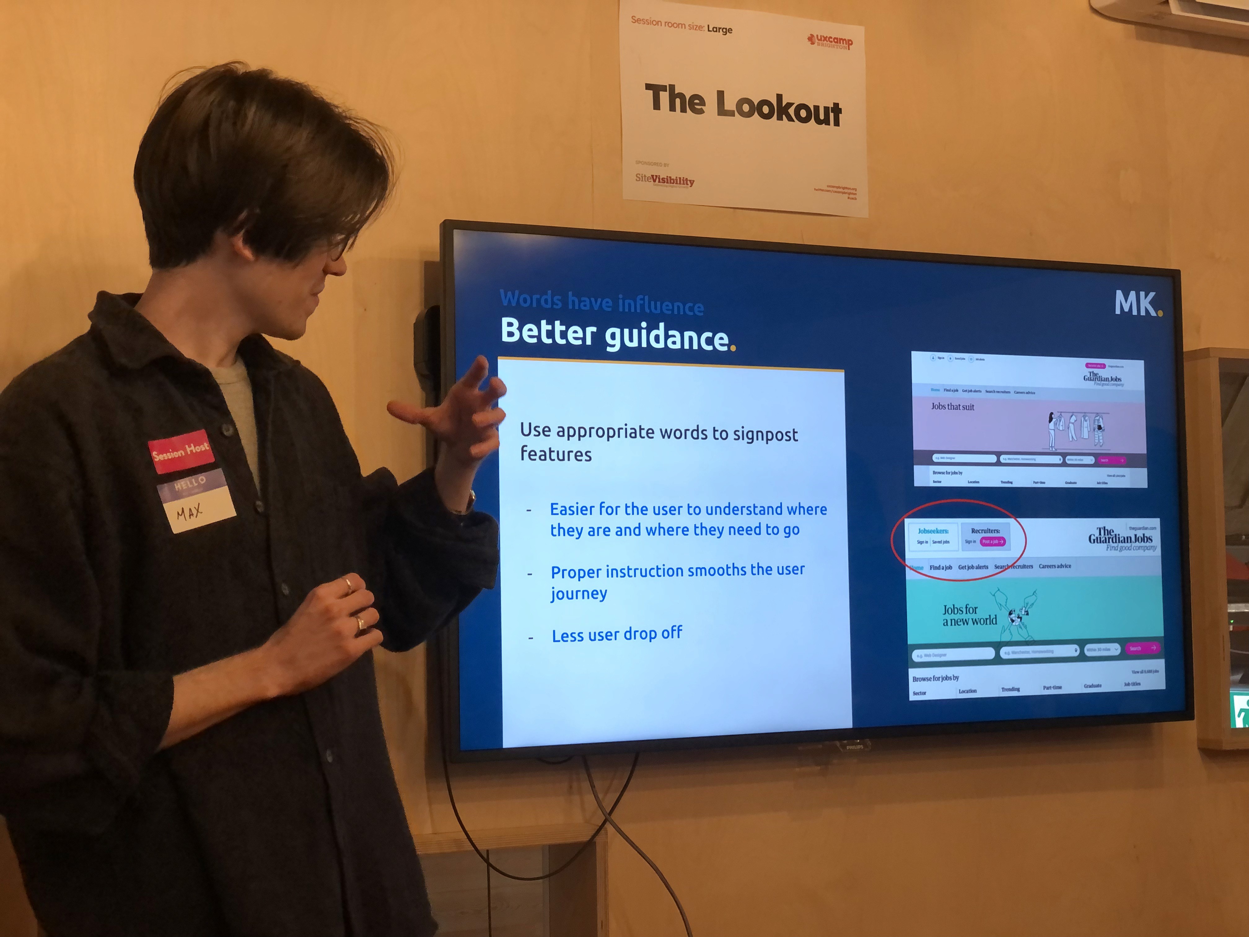 Max presenting in front of a screen at UX Camp