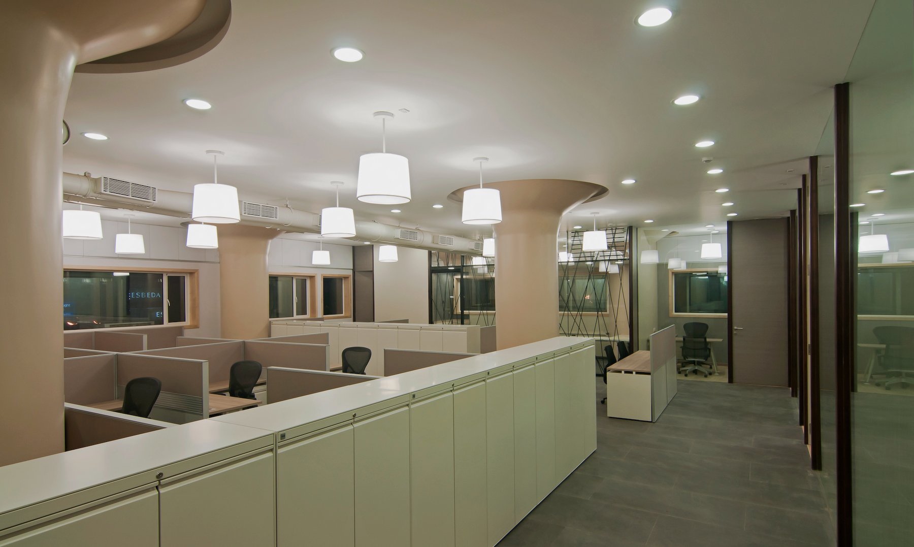 Nature-inspired preschool entrance with sculptural tree partitions and suspended green leaf ceiling panels.