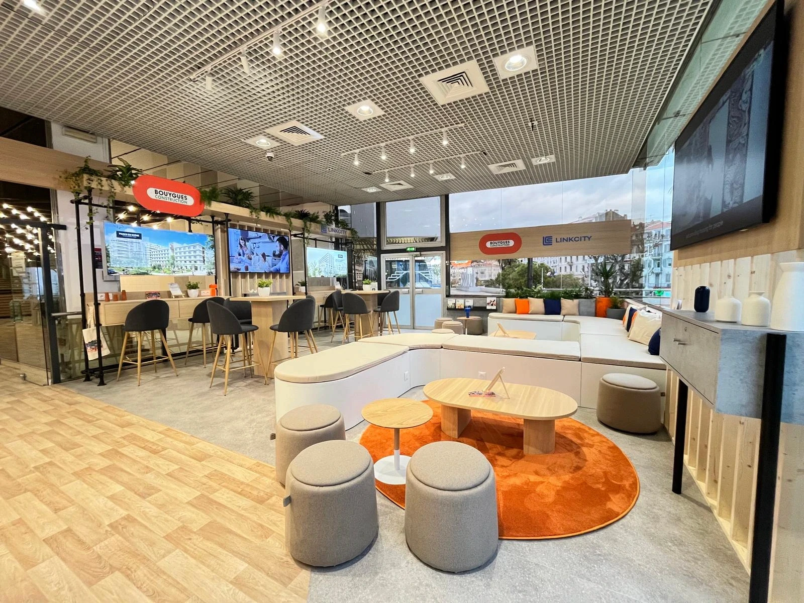 Stand Bouygues Construction & Linkcity conçu et réalisé par Expace au MIPIM Cannes 2026 – espace sur-mesure sur la Croisette avec accueil signature, lounge, écrans projets immobiliers et terrasse végétalisée.