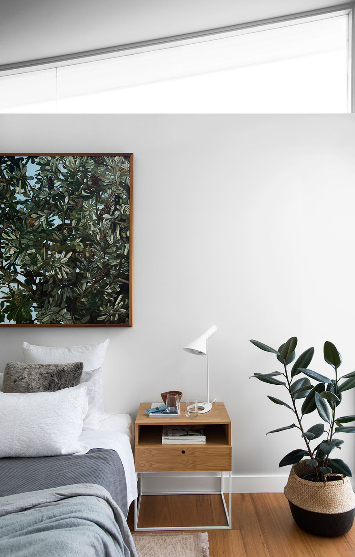 Quiet bedroom with restrained palette, timber bedside joinery, and soft natural light against white walls.
