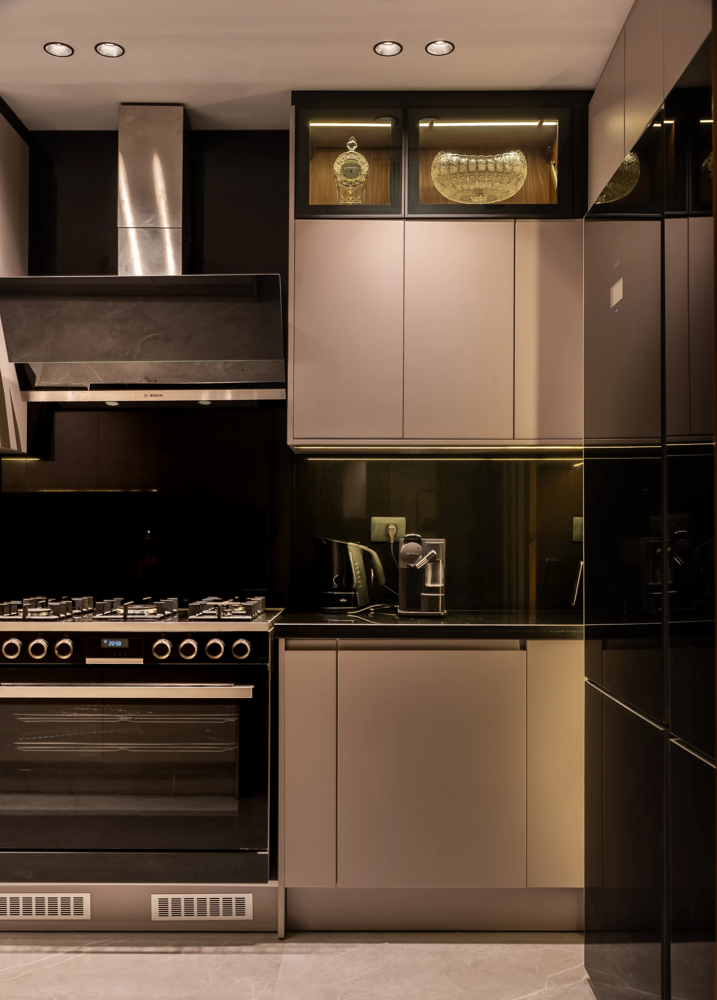 Compact modern kitchen at Mivida Twin Villa with grey cabinetry and dark stone surfaces.