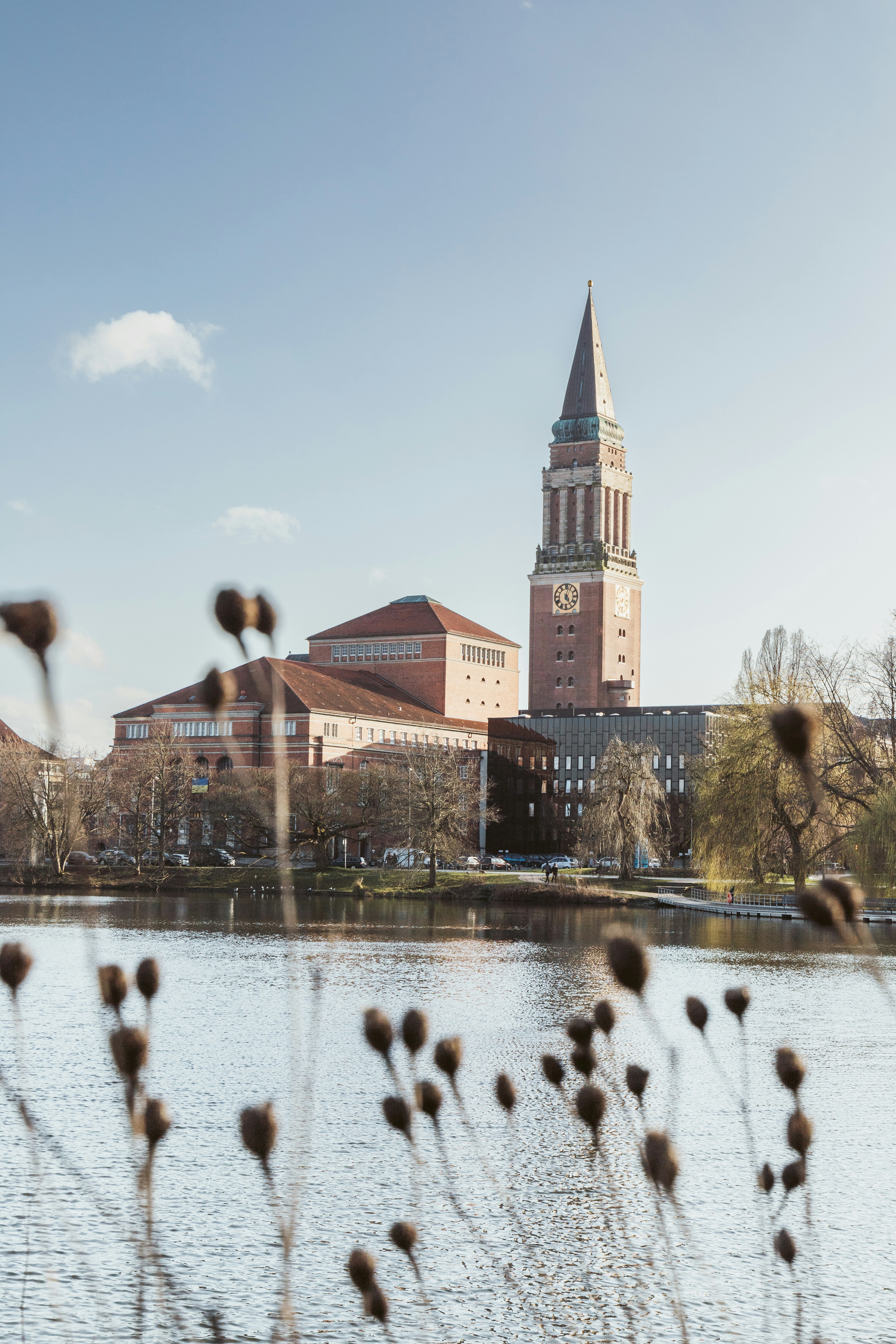 Das Kieler Rathaus in Schleswig-Holstein mit markantem Turm, rotem Backsteinbau und Blick über den Rathausplatzteich.