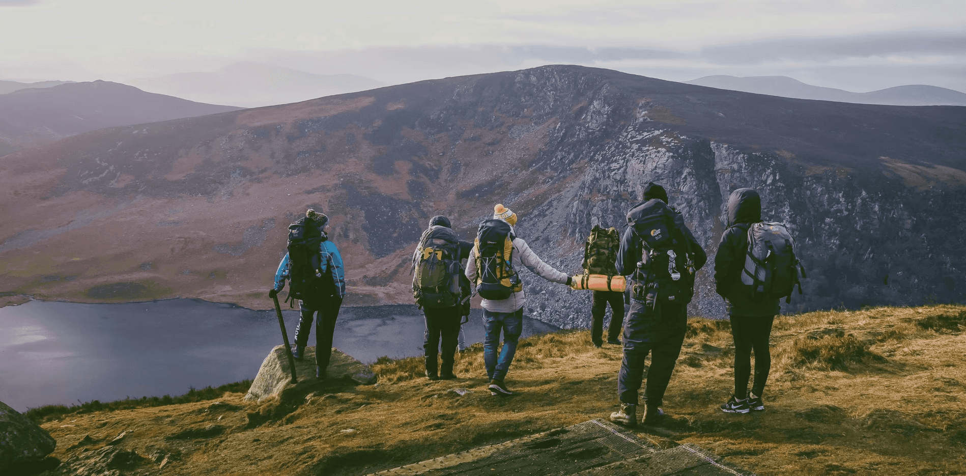 group of people on top of mountain under gray sky
