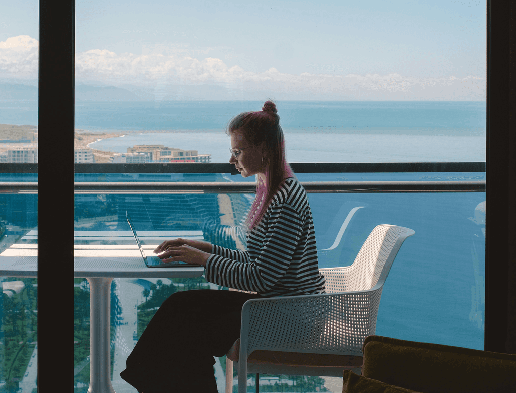 A person with glasses in front of computer and tech graphs with a tech graphic along their face