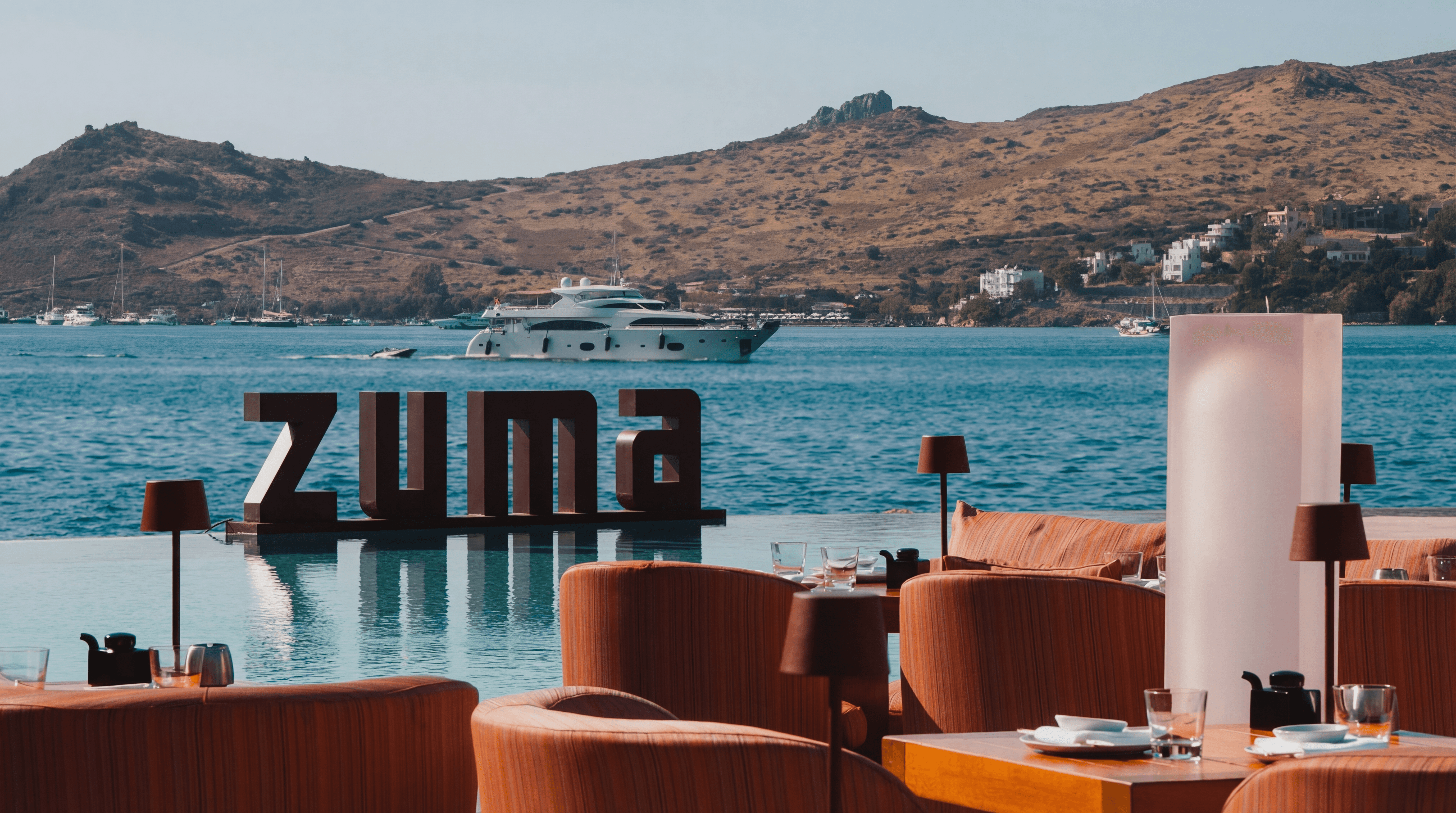Zuma Bodrum restaurant terrace at Yalıkavak Marina with modern Japanese dining setup and panoramic marina views at sunset