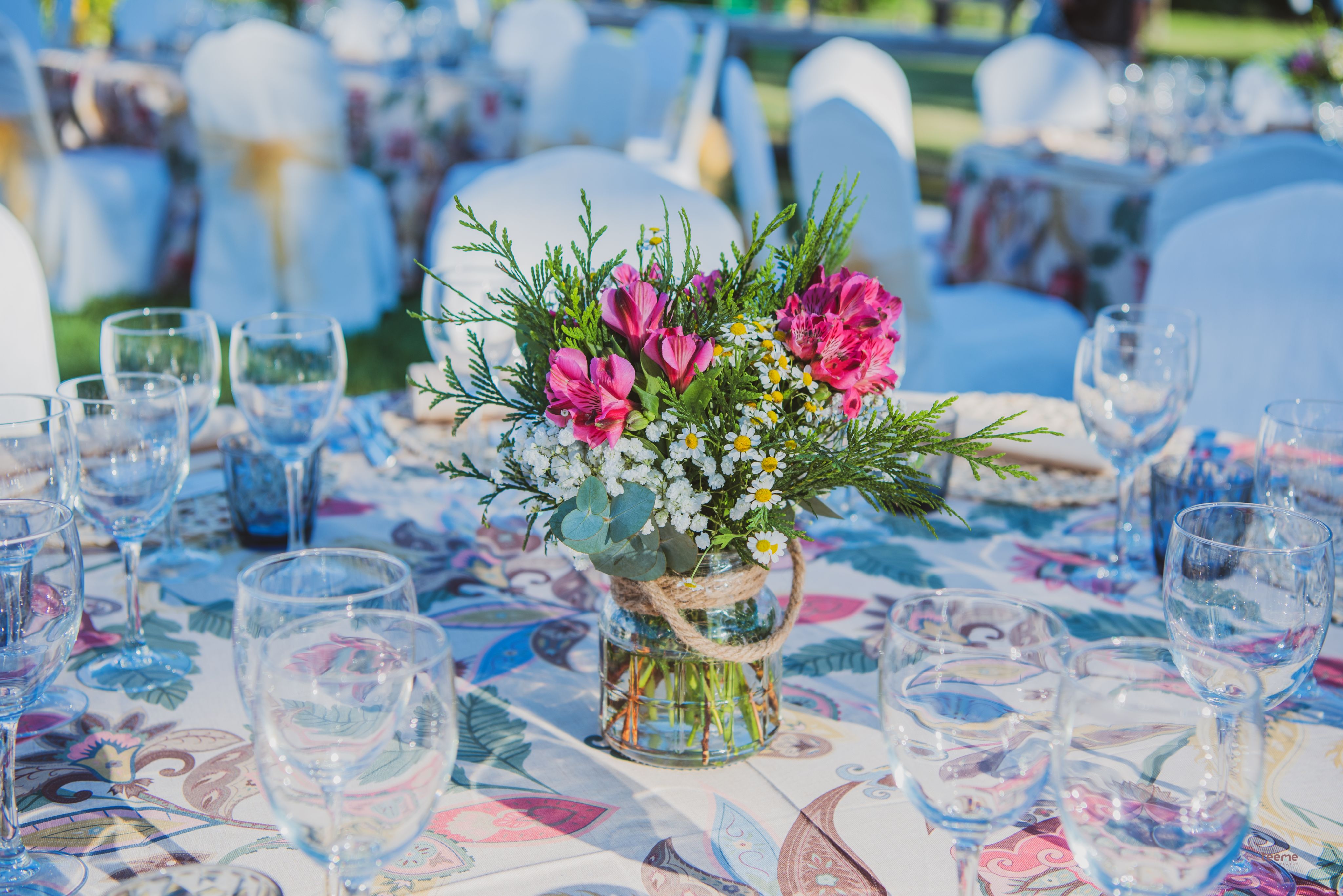A beautifully set dining table with white tablecloth, cutlery, and fresh greenery in a cozy, well-lit space.