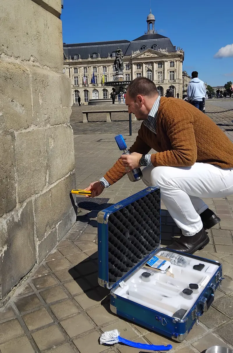 Technicien réalisant un diagnostic d’humidité sur un mur à Bordeaux