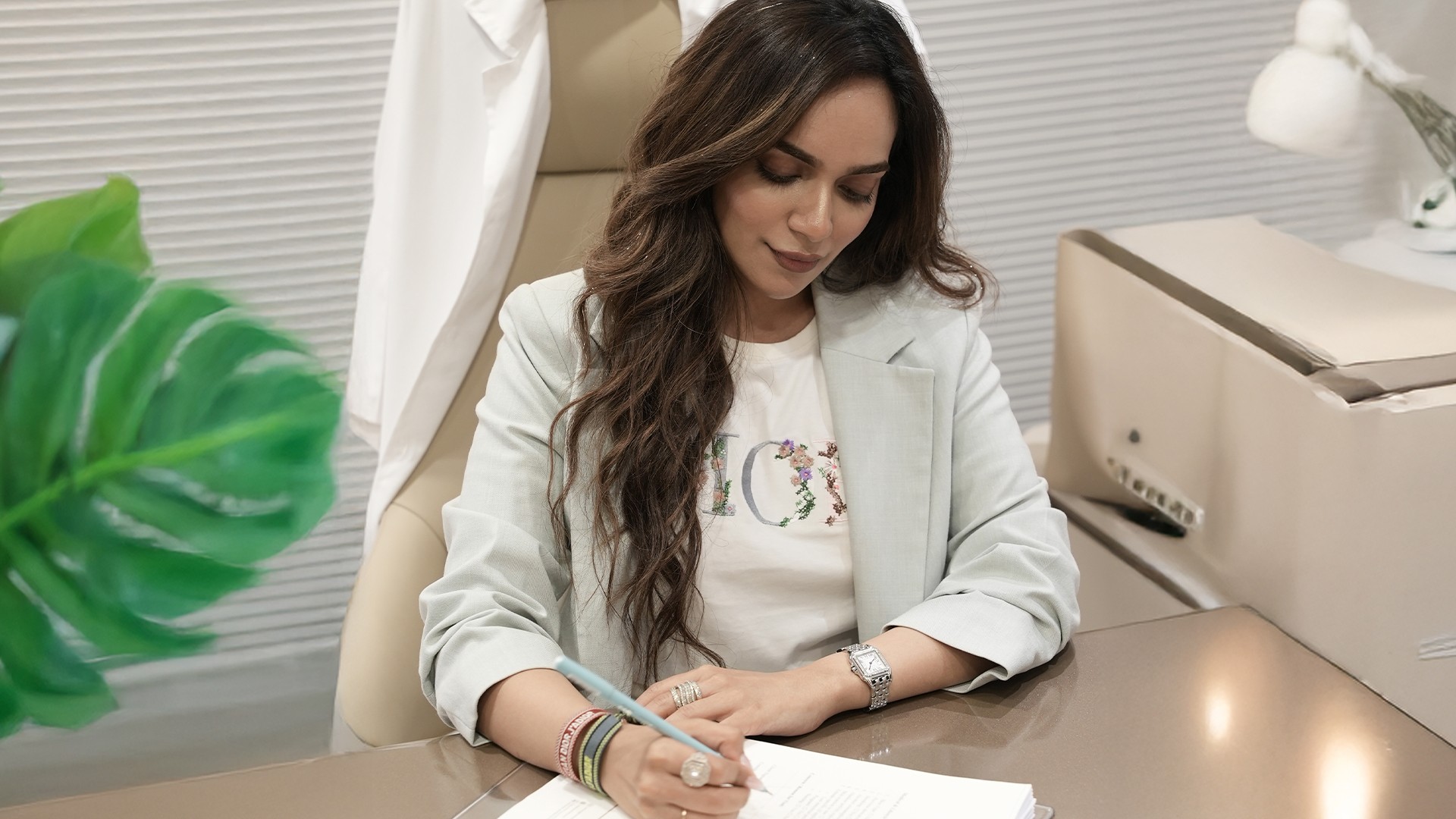 Portrait of a woman with long red hair and closed eyes, gently touching her face with both hands