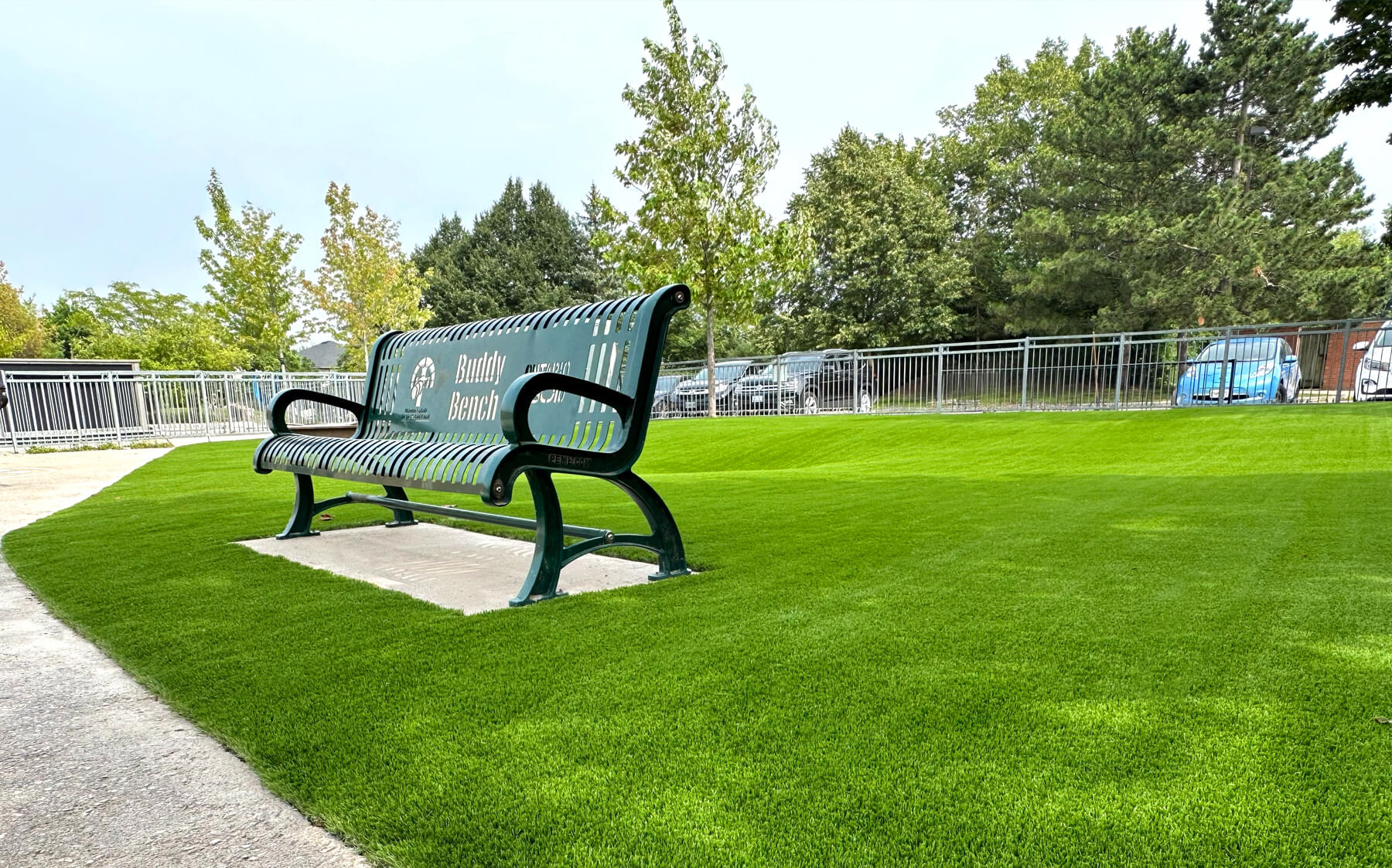A green bench resting on a grassy field, offering a peaceful spot to sit and enjoy the outdoors.