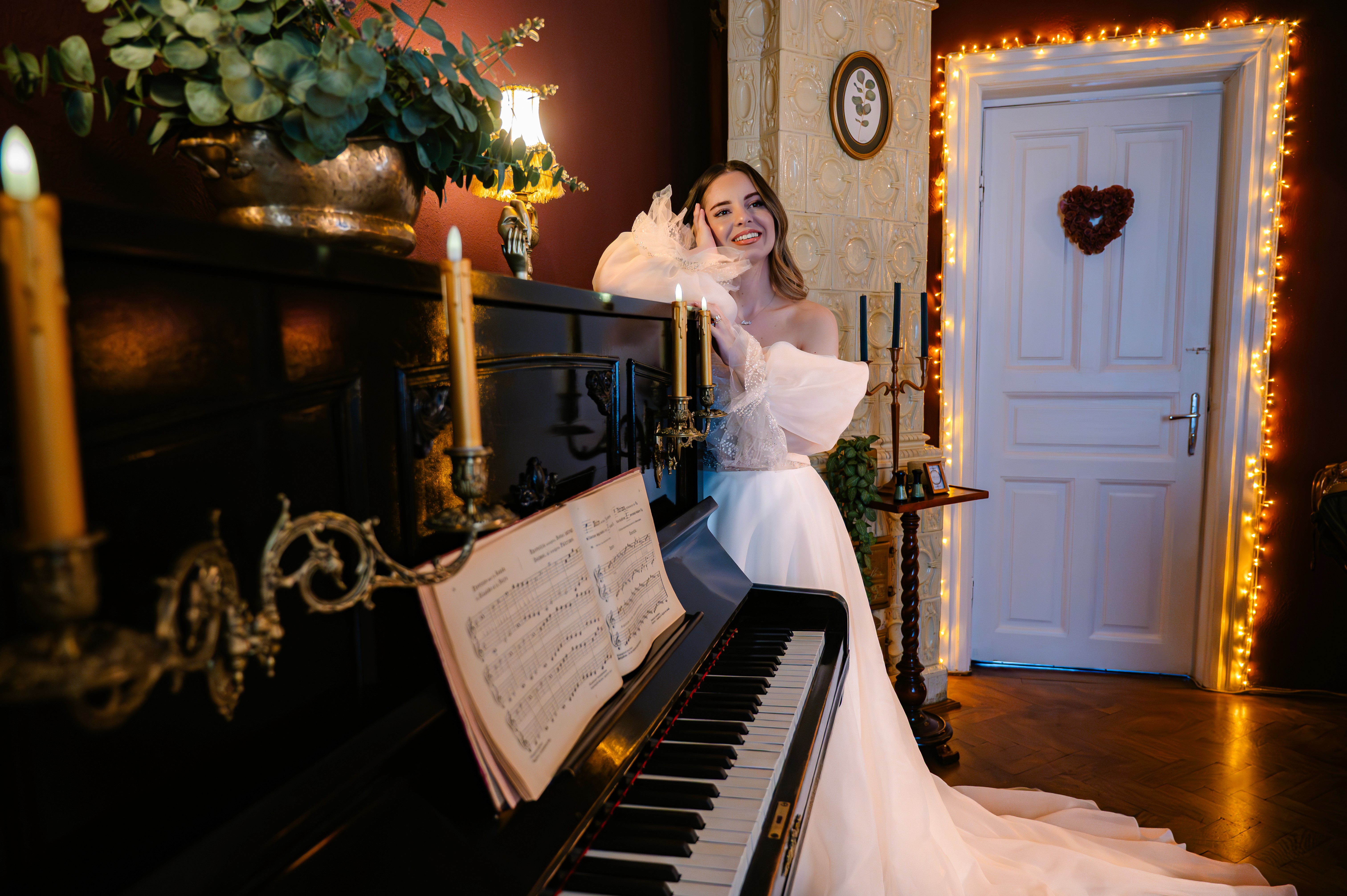 Mireasă în rochie albă elegantă langa pian negru, decor vintage cu plante, fotografie editorială nuntă București