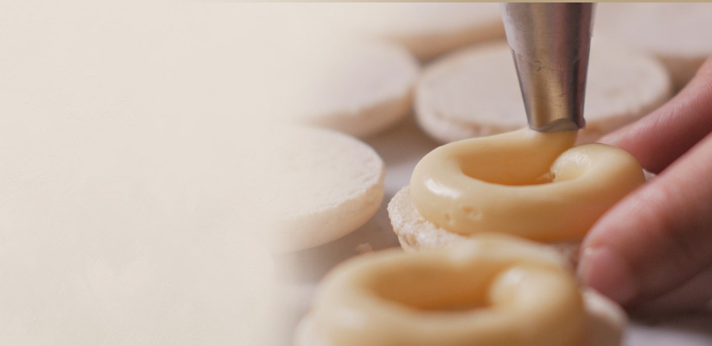 Piping white chocolate ganache for fleur mystérieuse macaron