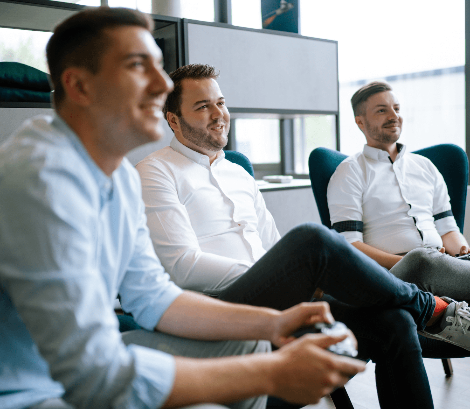 Drei Männer sitzen und spielen mit der Konsole