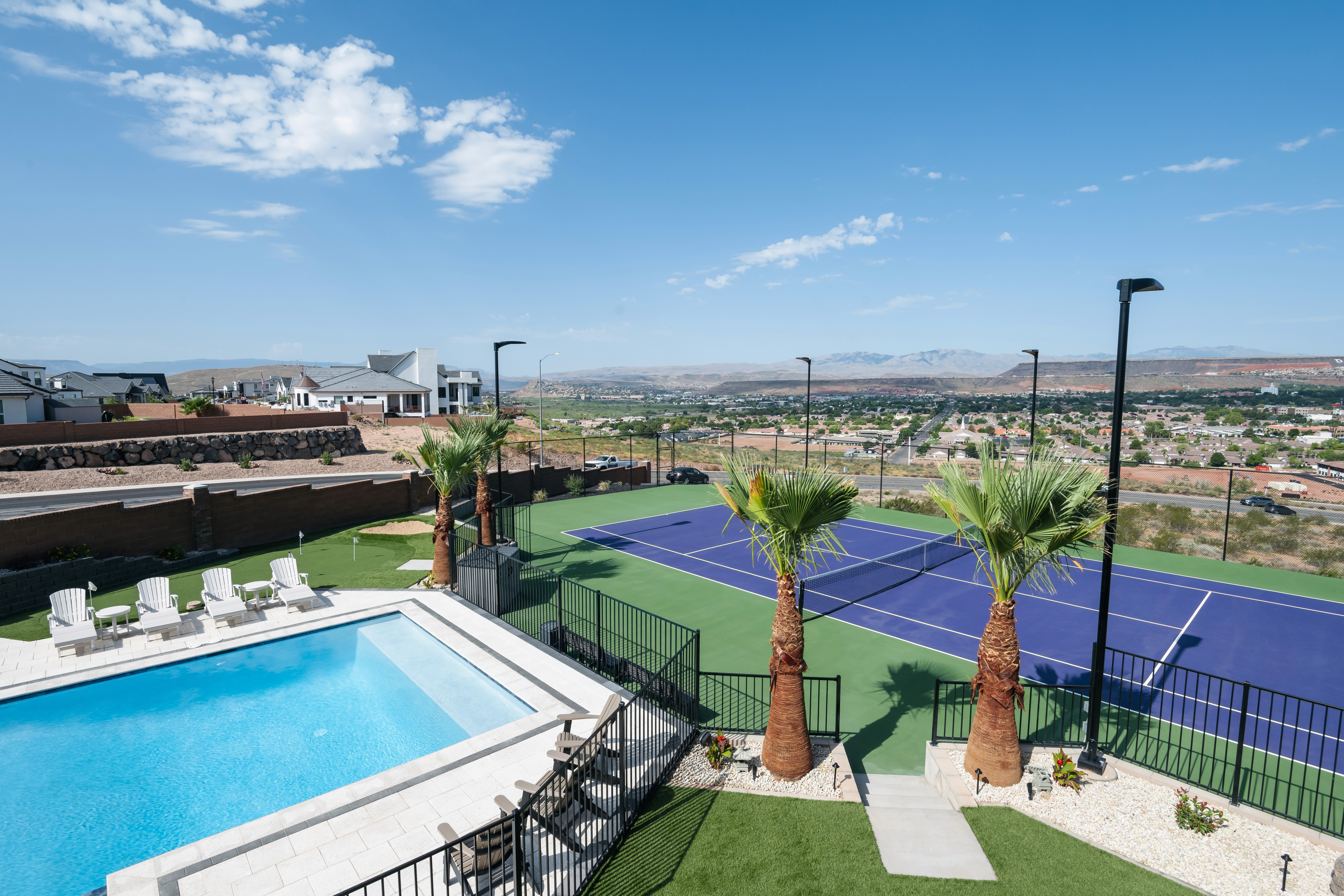 Custom backyard with a pool, putting green, and pickleball court with views of the St. Geroge, Utah valley.