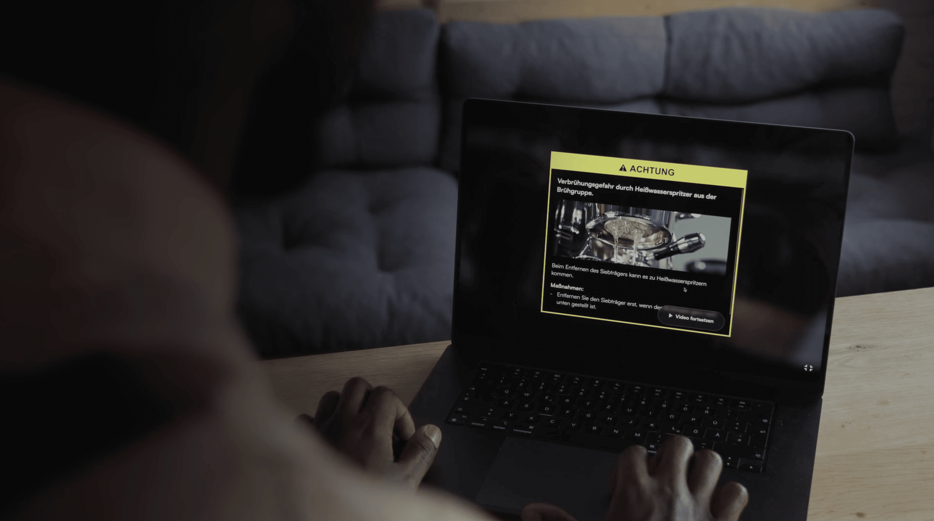 person is sitting in front of a laptop and a warning pops up on the video screen