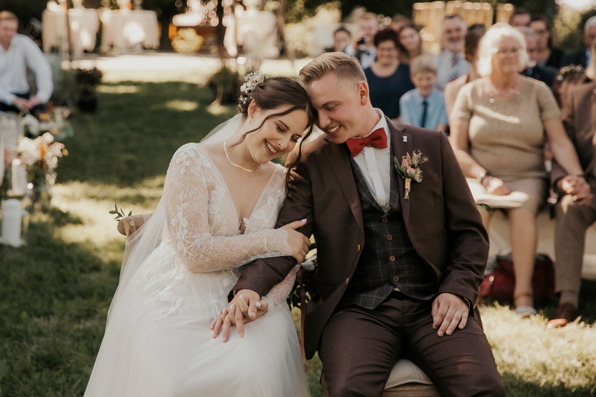 Ein glückliches Brautpaar lacht während der persönlichen Hochzeitsrede von Denise