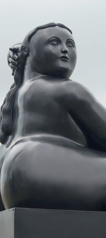 Two hands in an elegant gesture, one above the other, against a dark background