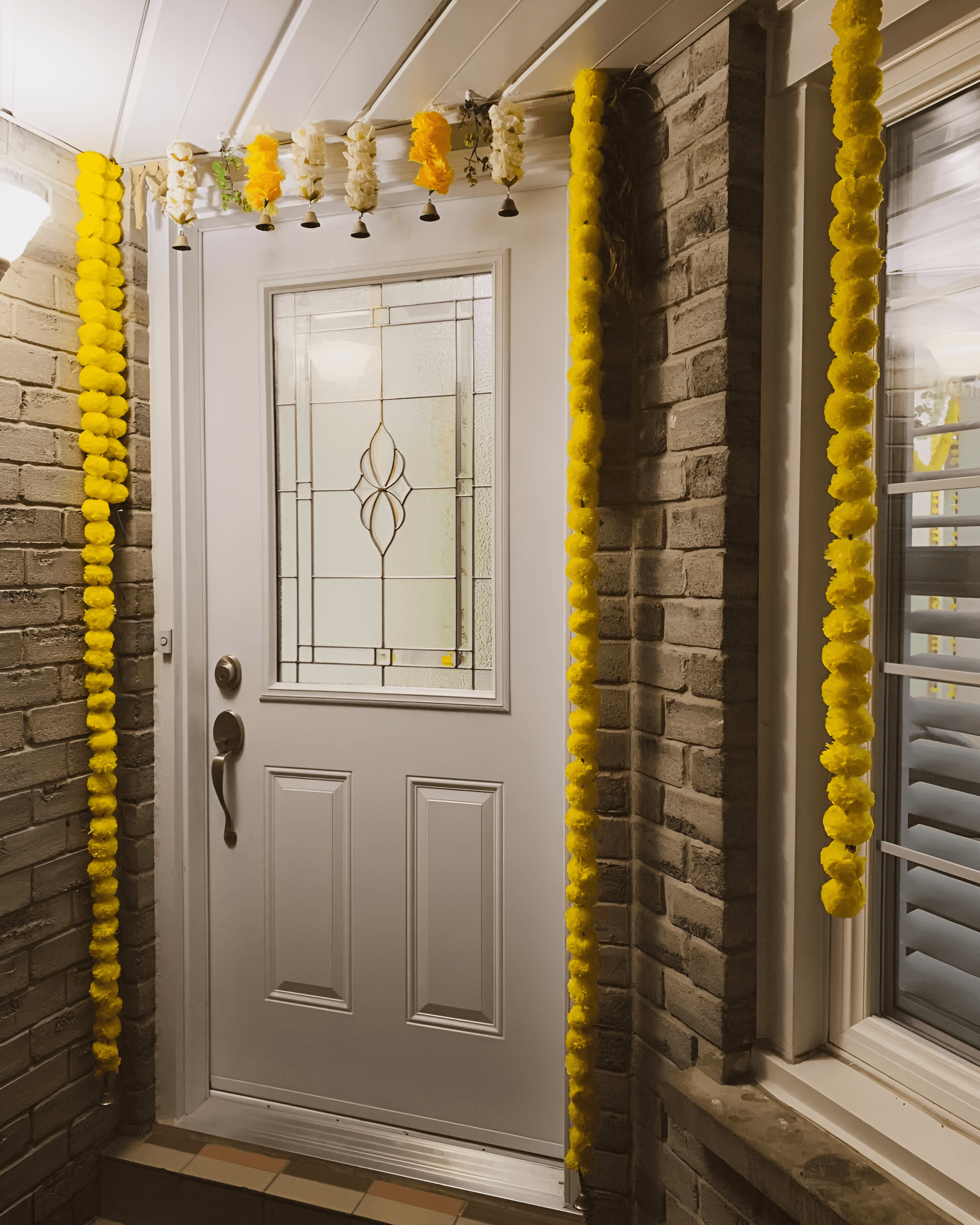 Home entrance decorated with real yellow marigold flower, creating a traditional wedding decor look in Indirapuram & Rohini