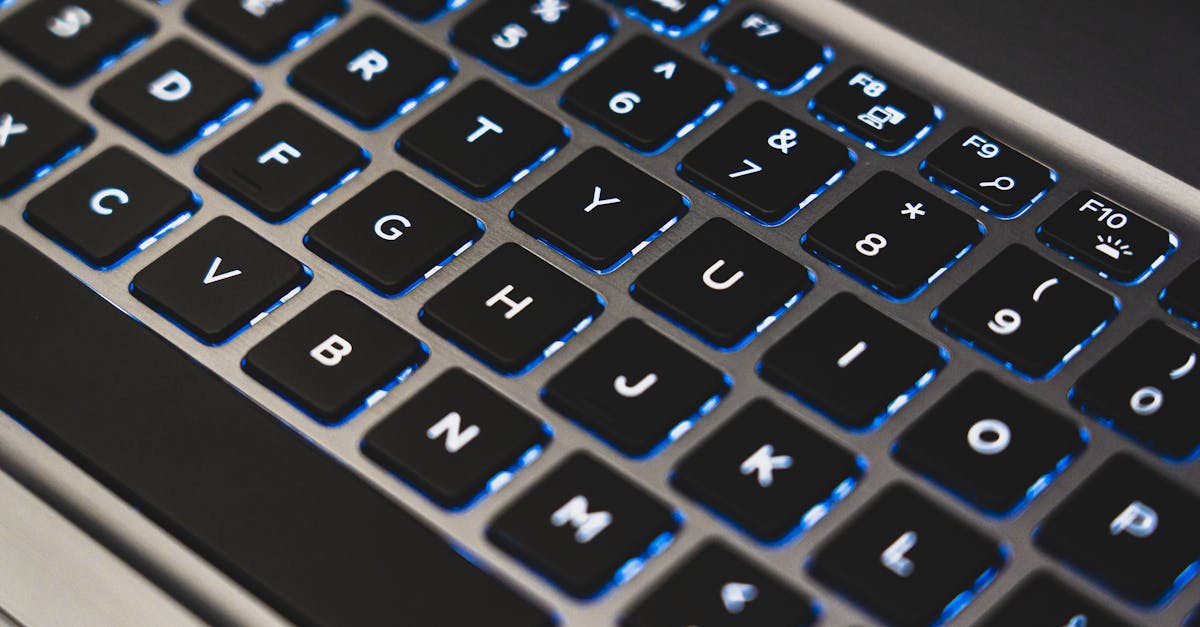 A detailed view of a backlit laptop keyboard with glowing blue lights.