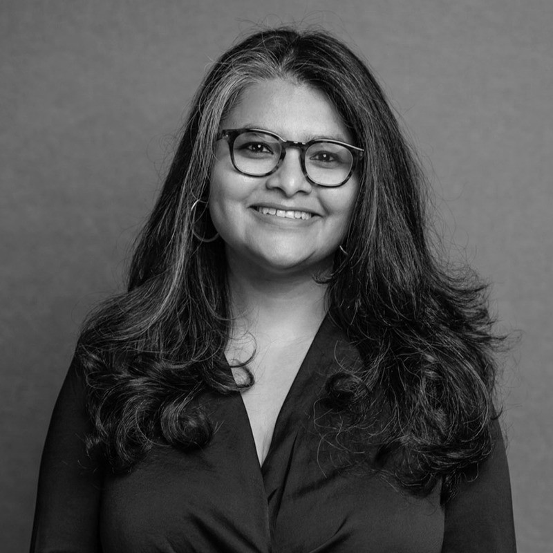 Woman working at desk with laptop and phone.