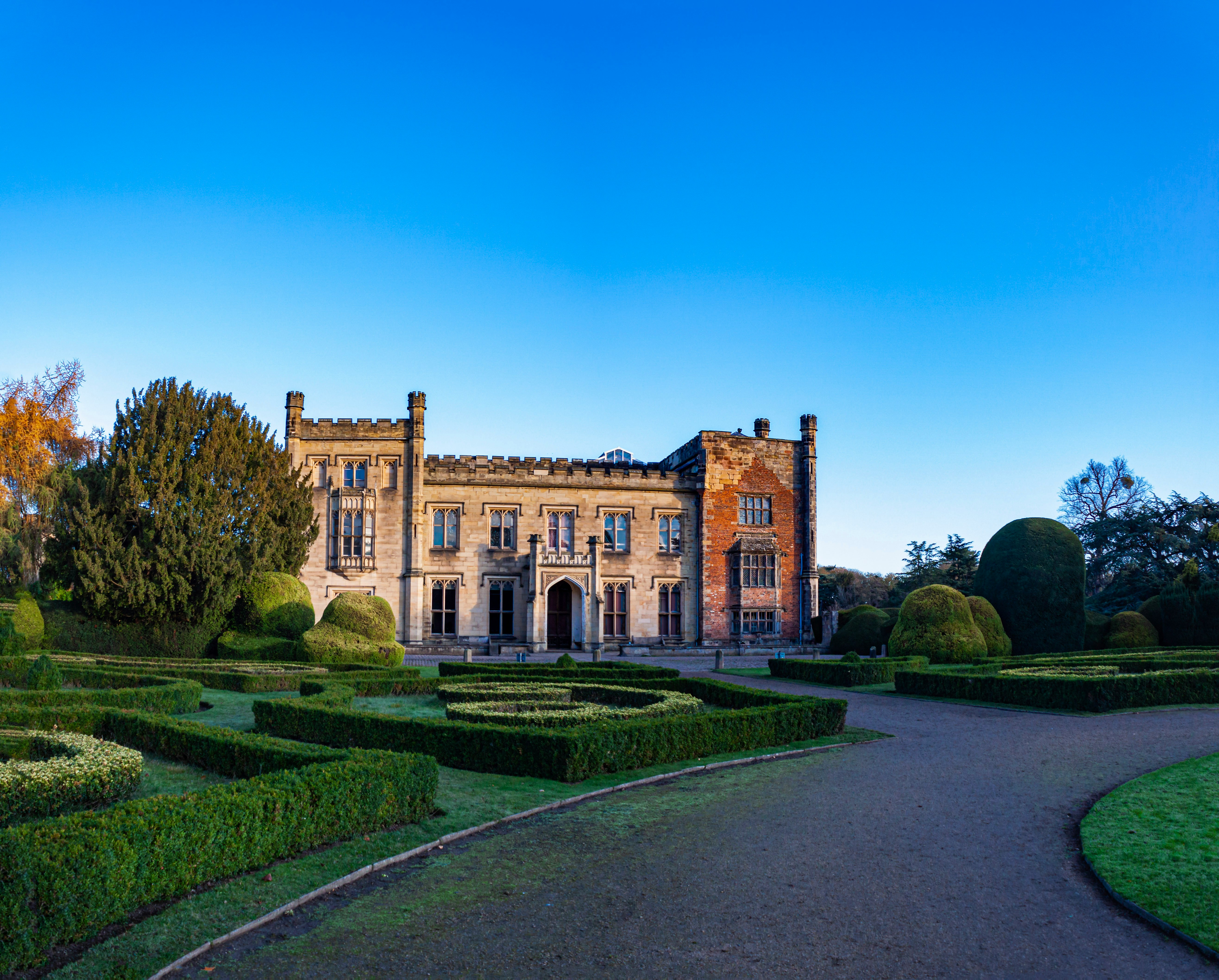 a large building surrounded by hedges and trees