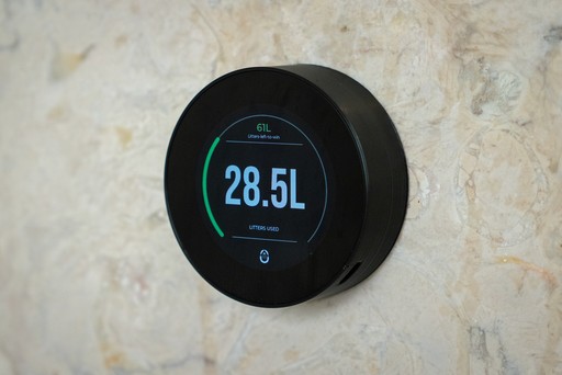 Savearth smart device installed in a hotel shower for water tracking.