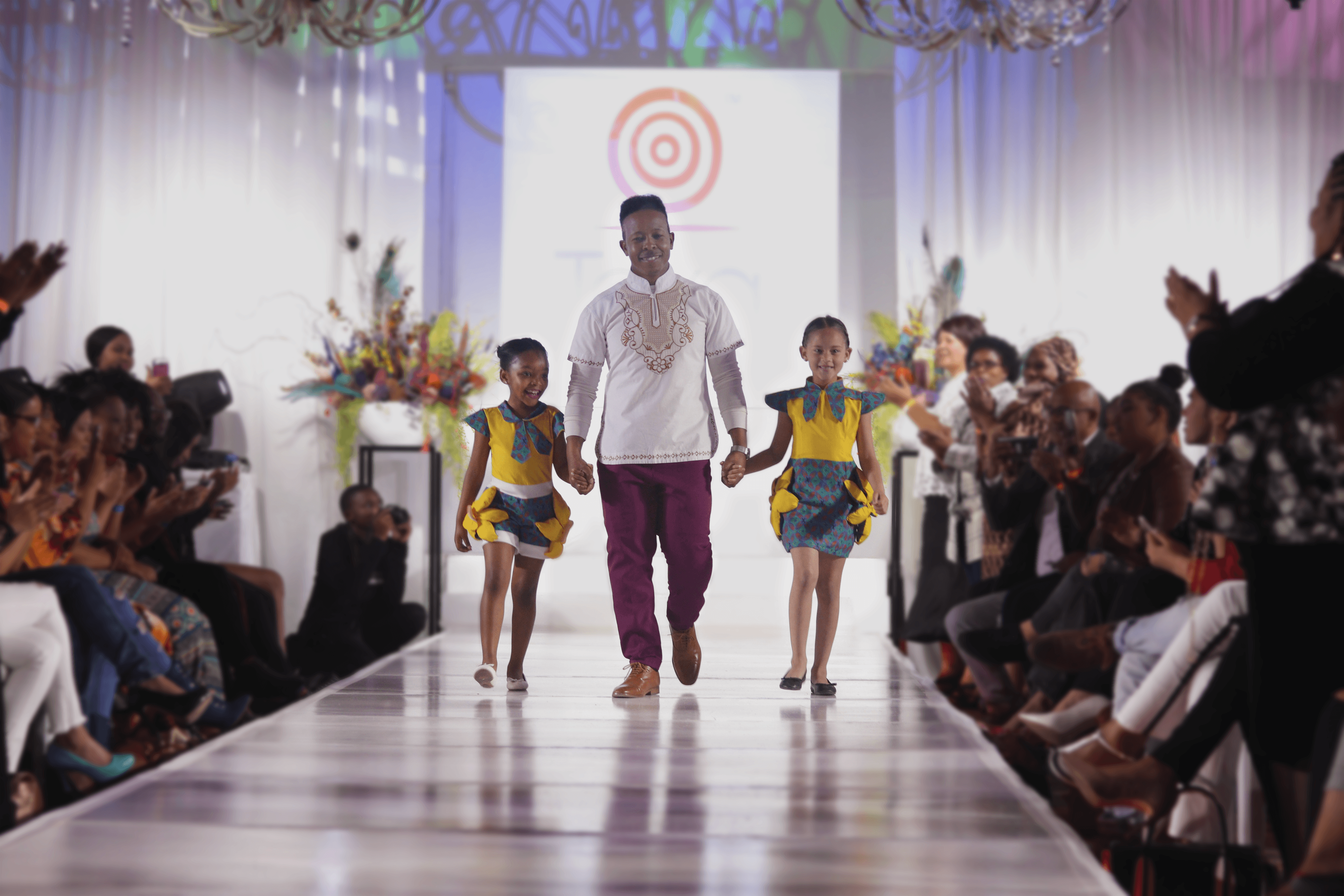KN Studios Founder and two little girls walking down catwalk in the merchandise