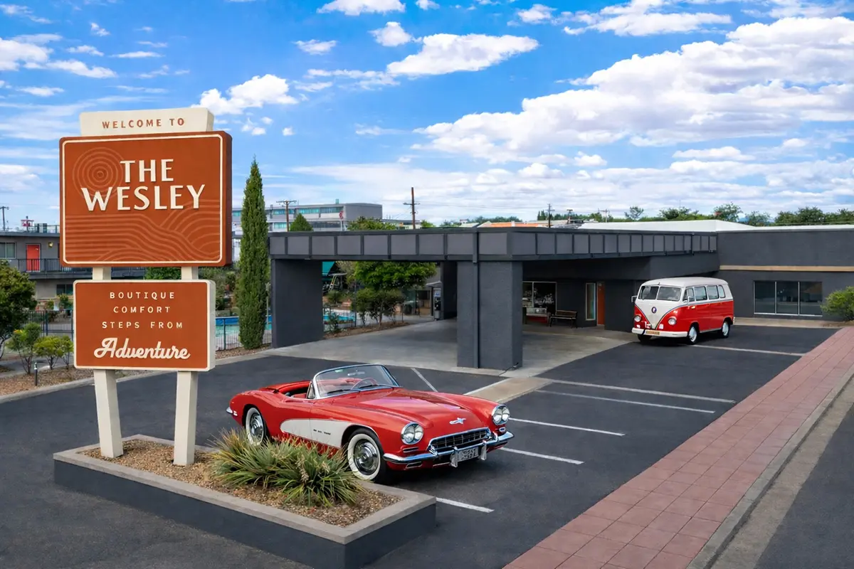 Exterior of The Wesley Hotel in Page, Arizona with red, classic cars on the parking lot